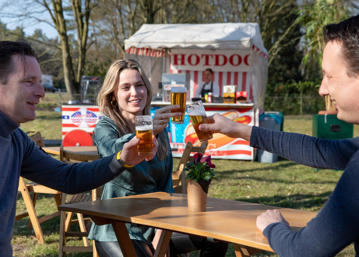 Gasten proosten bij de hotdogkraam van De Gezellige Brabander